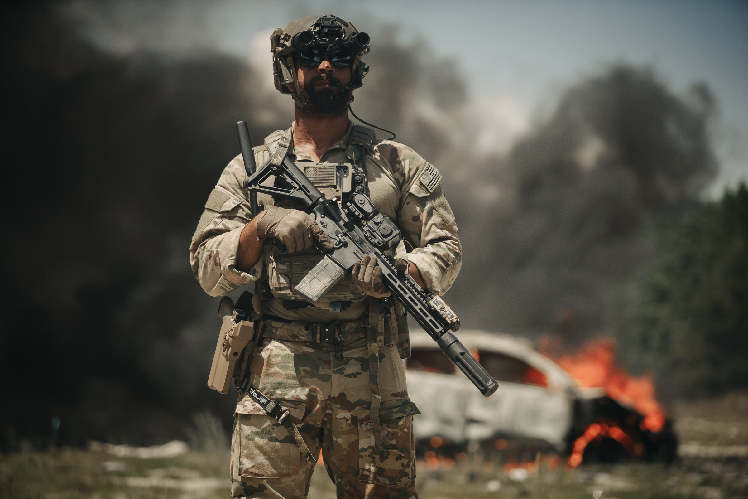 Operator holding a suppressed carbine in the field